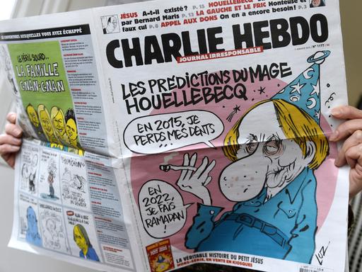 Eine Person hält die Ausgabe der Zeitschrift "Charlie Hebdo" vom 7. Januar 2015 in Händen.