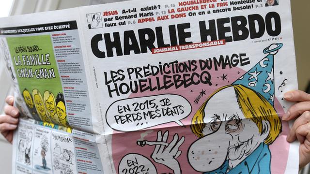 Eine Person hält die Ausgabe der Zeitschrift "Charlie Hebdo" vom 7. Januar 2015 in Händen.