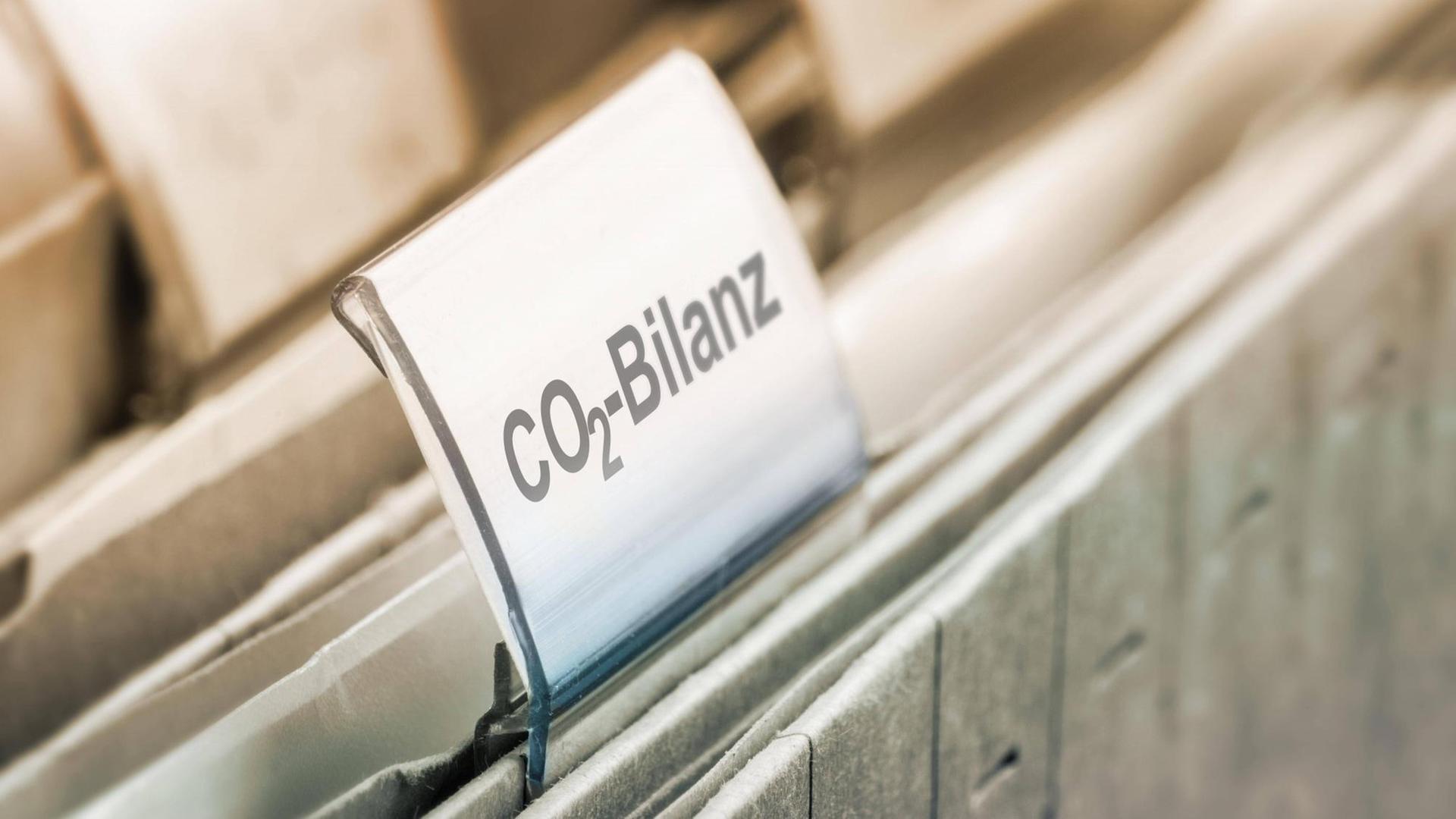 Ein Schild mit der Aufschrift CO2-Bilanz steckt auf einem Hängeordner (Symbolbild) Ein Schild mit der Aufschrift CO2-Bilanz steckt auf einem Hängeordner (Symbolbild)