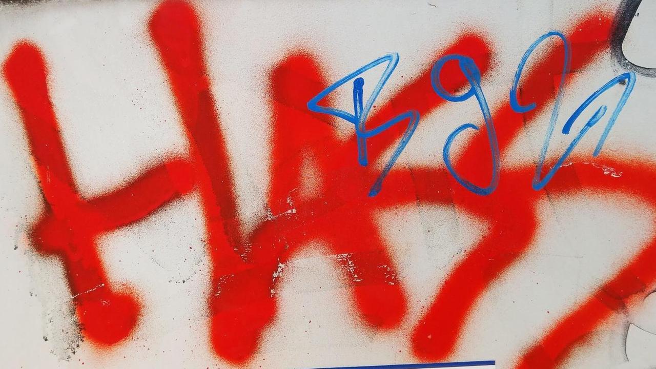 Das Wort "Hass" steht gesprüht in roter Farbe auf einem Stromkasten. Das Wort "Hass" steht gesprüht in roter Farbe auf einem Stromkasten.