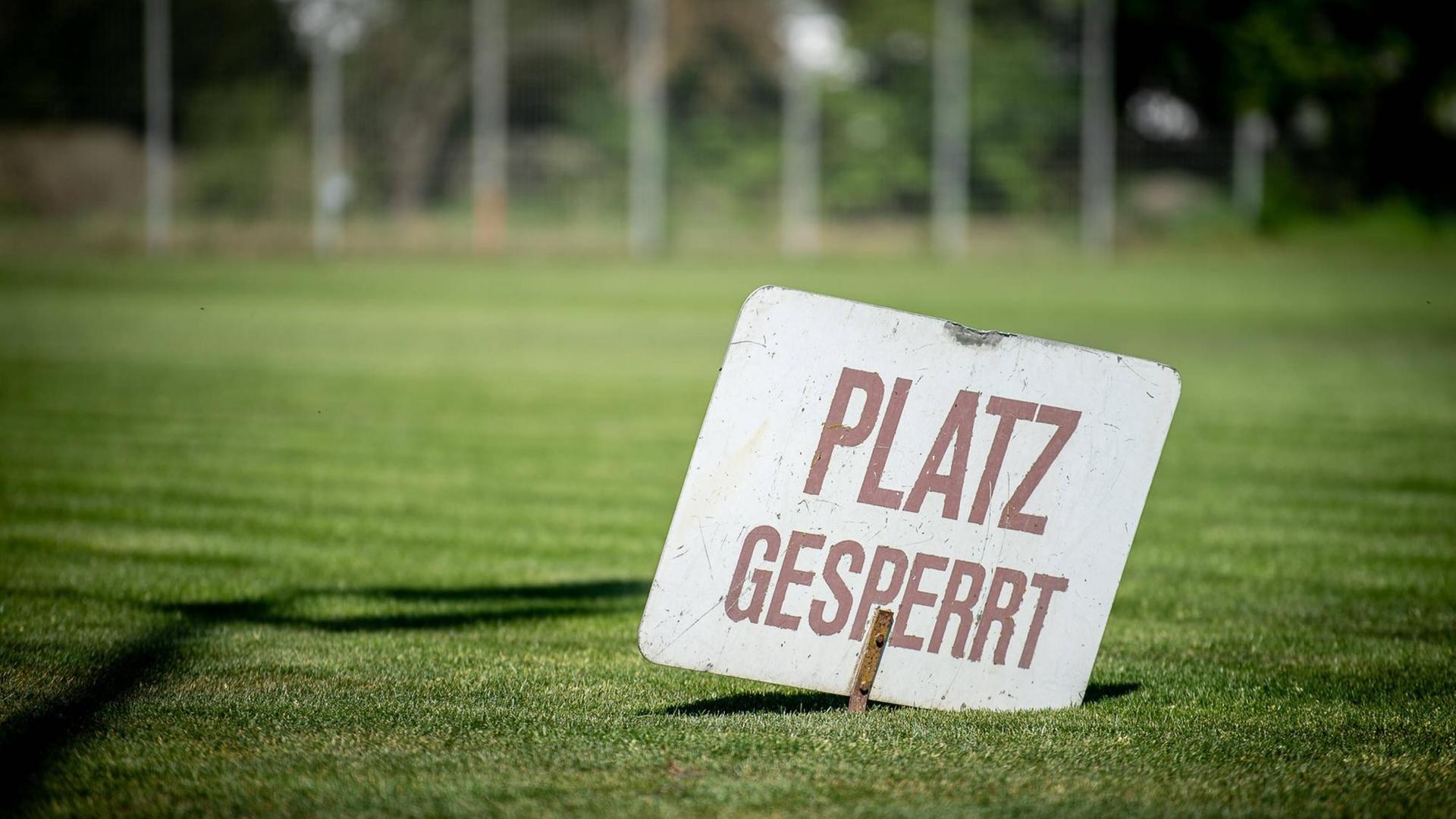 Ein Schild mit der Aufschrift "Platz gespresst" steckt im Rasen eines Vereinsspielfeldes Ein Schild mit der Aufschrift "Platz gespresst" steckt im Rasen eines Vereinsspielfeldes