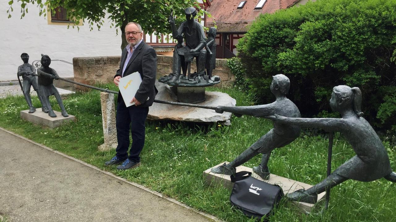 Stadtführer Dieter Hagen vor dem Schusterbrunnen in Herzogenaurach. Der Brunnsn ist ein Symbol für das Schuster-Handwerk und den Wettstreit von Adidas und Puma. Stadtführer Dieter Hagen vor dem Schusterbrunnen in Herzogenaurach. Der Brunnsn ist ein Symbol für das Schuster-Handwerk und den Wettstreit von Adidas und Puma.
