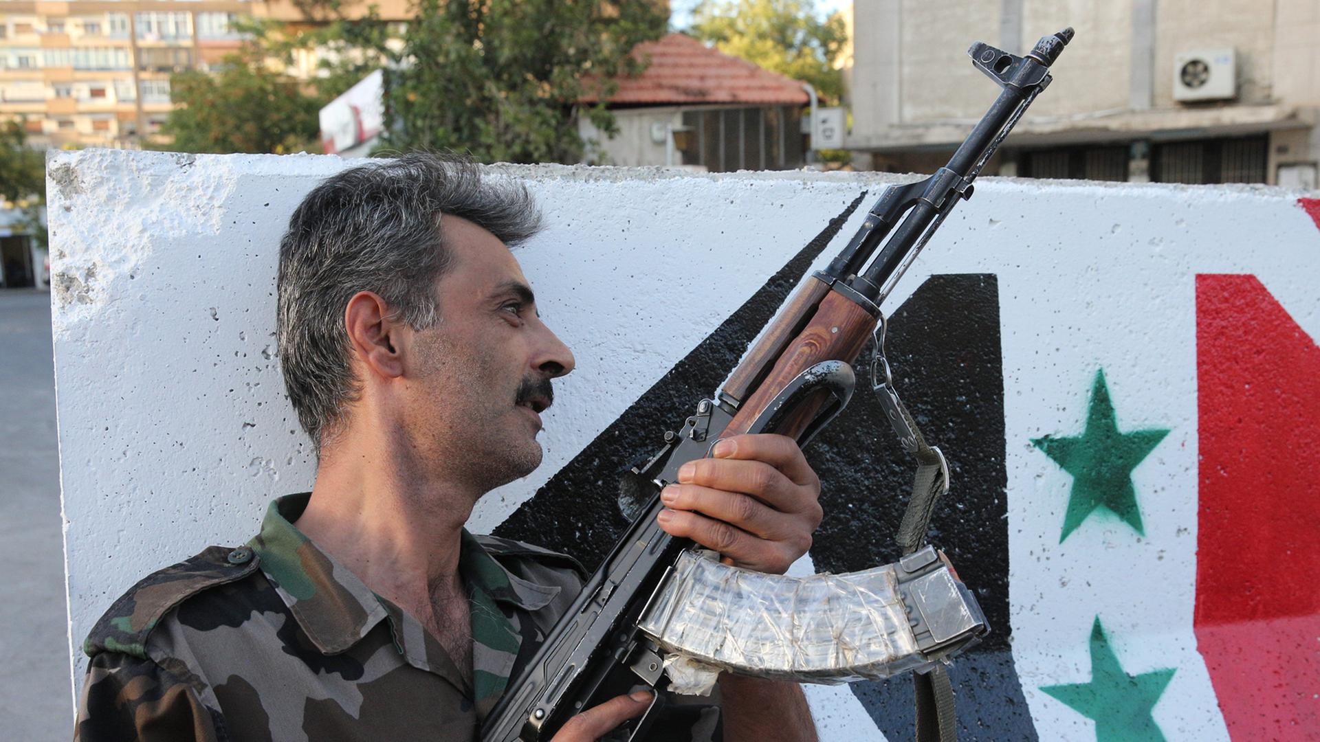 Ein syrischer Soldat mit Maschinengewehr an einem Kontrollpunkt in Damaskus. Ein syrischer Soldat mit Maschinengewehr an einem Kontrollpunkt in Damaskus.