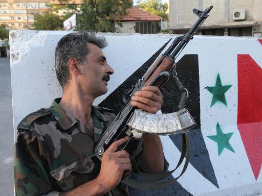 Ein syrischer Soldat mit Maschinengewehr an einem Kontrollpunkt in Damaskus.