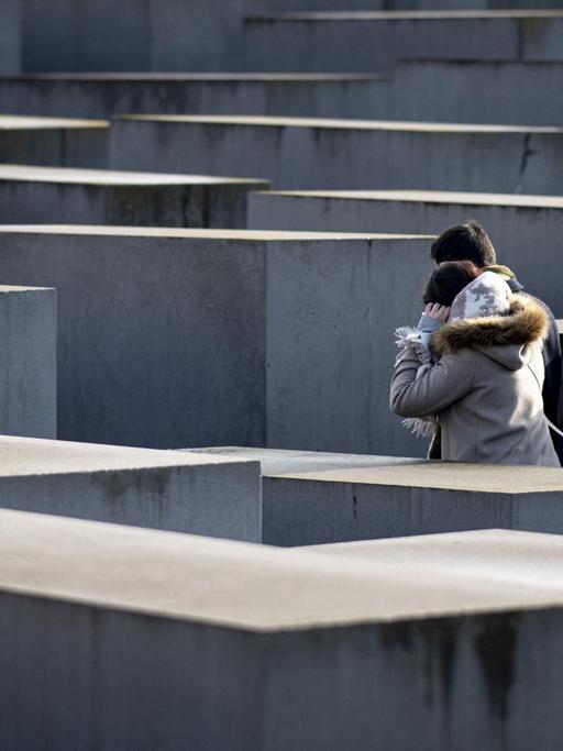 Zwei Personen gehen vor dem Internationalen Tag des Gedenkens an die Opfer des Holocaust durch das Denkmal für die ermordeten Juden Europas. Der Holocaust-Gedenktag wird am 27.01.2021 begangen.