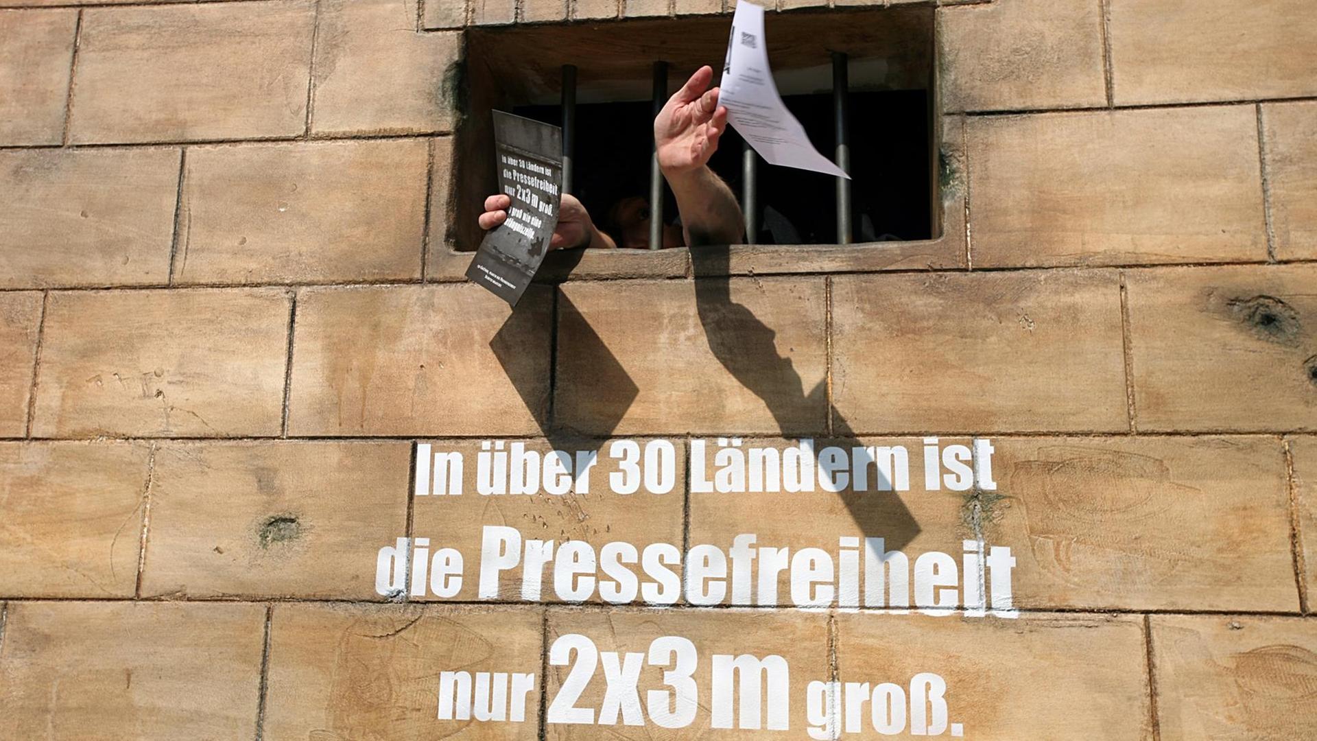 Auf einer Gefängnismauer steht "In über 30 Ländern ist die Pressefreiheit 2 mal 3 Meter groß" Auf einer Gefängnismauer steht "In über 30 Ländern ist die Pressefreiheit 2 mal 3 Meter groß"