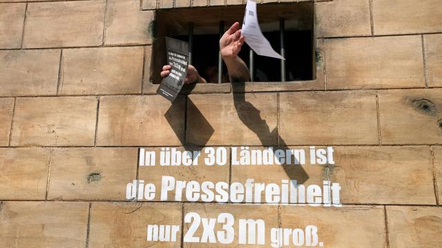Auf einer Gefängnismauer steht "In über 30 Ländern ist die Pressefreiheit 2 mal 3 Meter groß"
