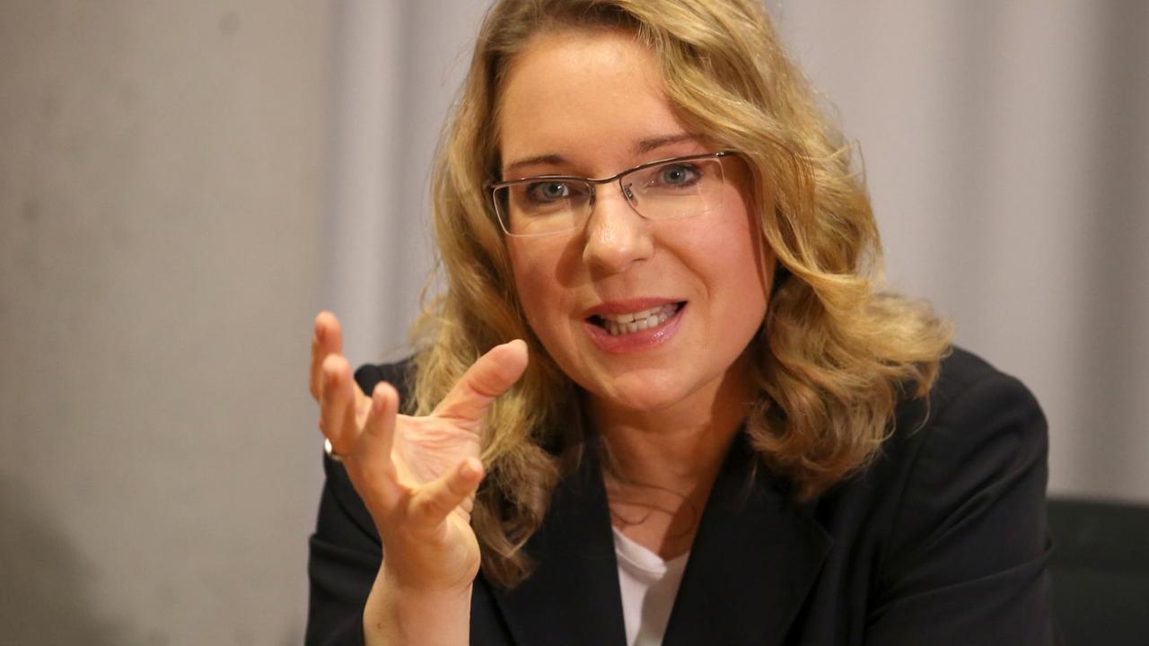 Claudia Kemfert spricht bei einer Konferenz im schwarzen Blazer und betont ihre Wort mit einer Handbewegung Claudia Kemfert spricht bei einer Konferenz im schwarzen Blazer und betont ihre Wort mit einer Handbewegung