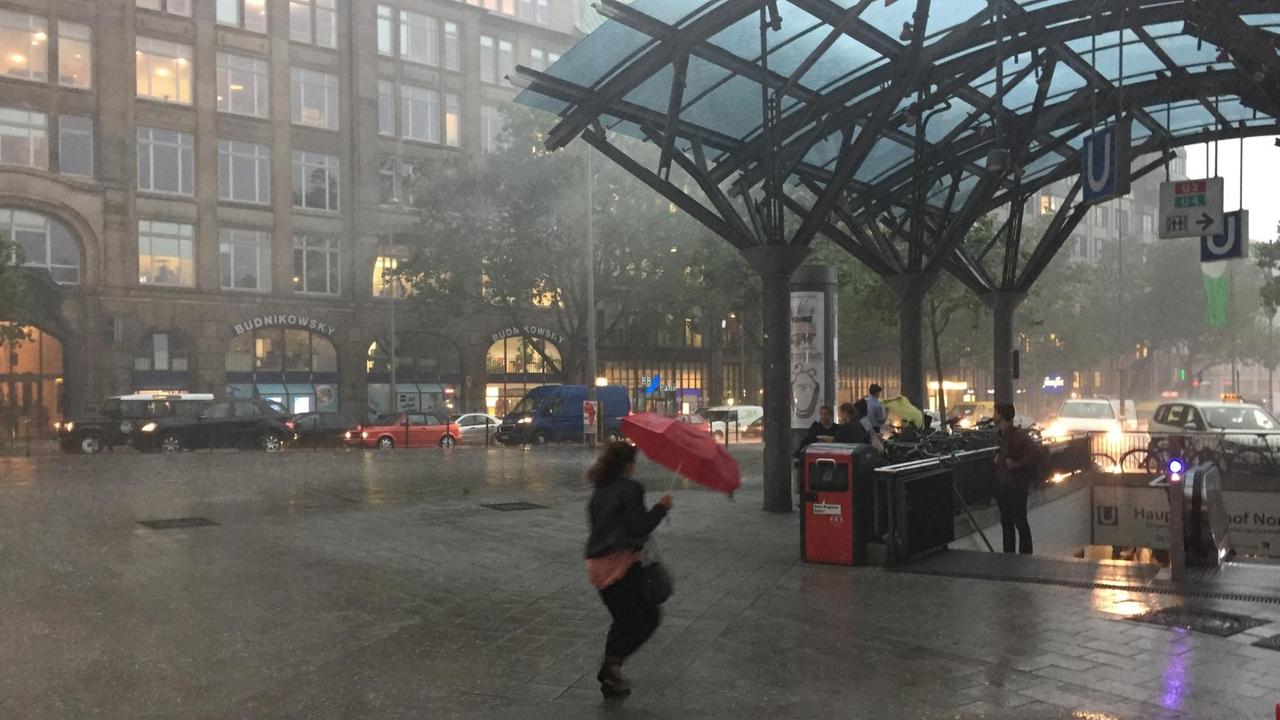 Passanten suchen am 22.06.2017 während eines starken Gewitters Schutz unter dem Dach der U-Bahnstation am Hauptbahnhof in Hamburg.