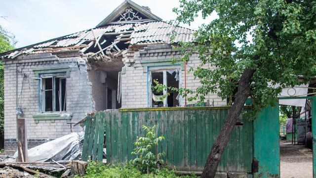 Ein Mann sitzt am Stadtrand von Slowjansk vor seinem zerstörten Haus.