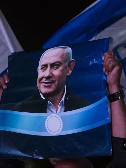 Unterstützer von Israels Ministerpräsident Benjamin Netanjahu halten bei einer Demonstration in Tel Aviv Plakate des Politikers hoch
