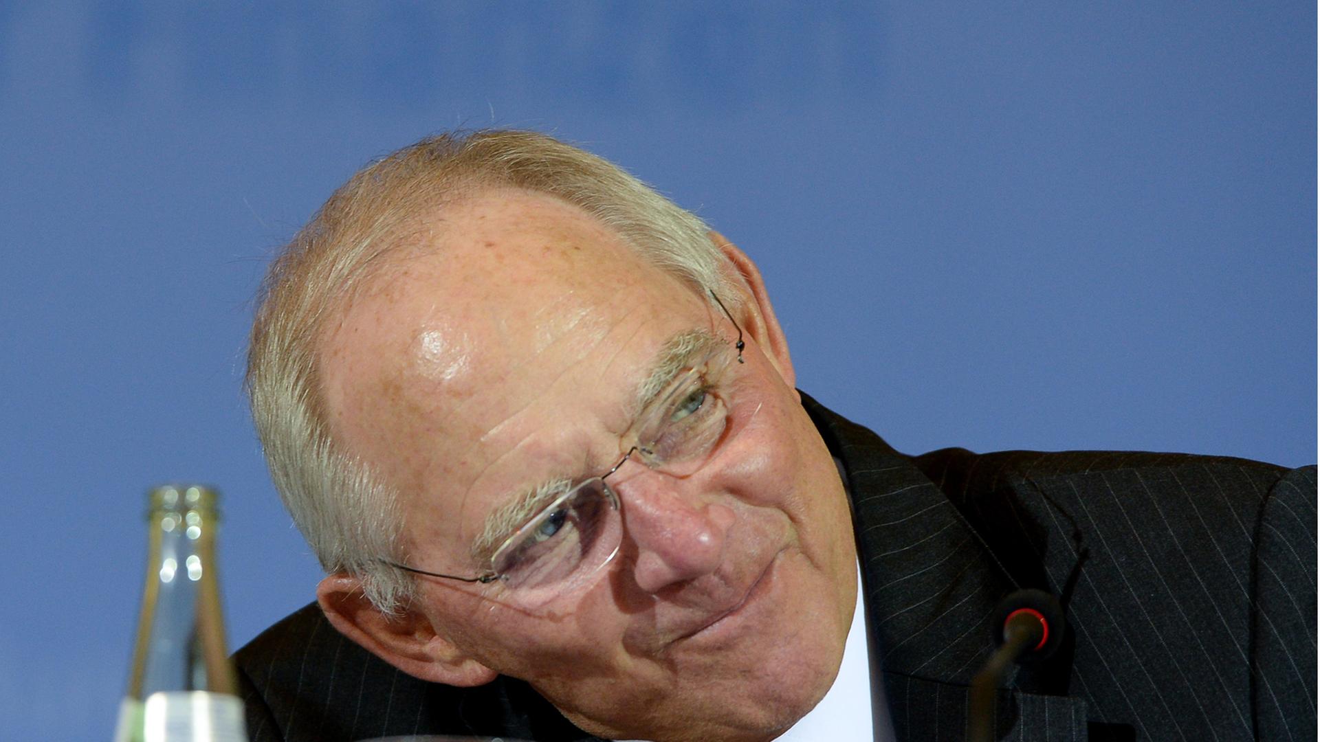 Bundesfinanzminister Wolfgang Schäuble wartet während einer Pressekonferenz in Berlin zu den Ergebnissen der Steuerschätzung auf Fragen der Journalisten. Er legt den Kopf zur Seite und lächelt.