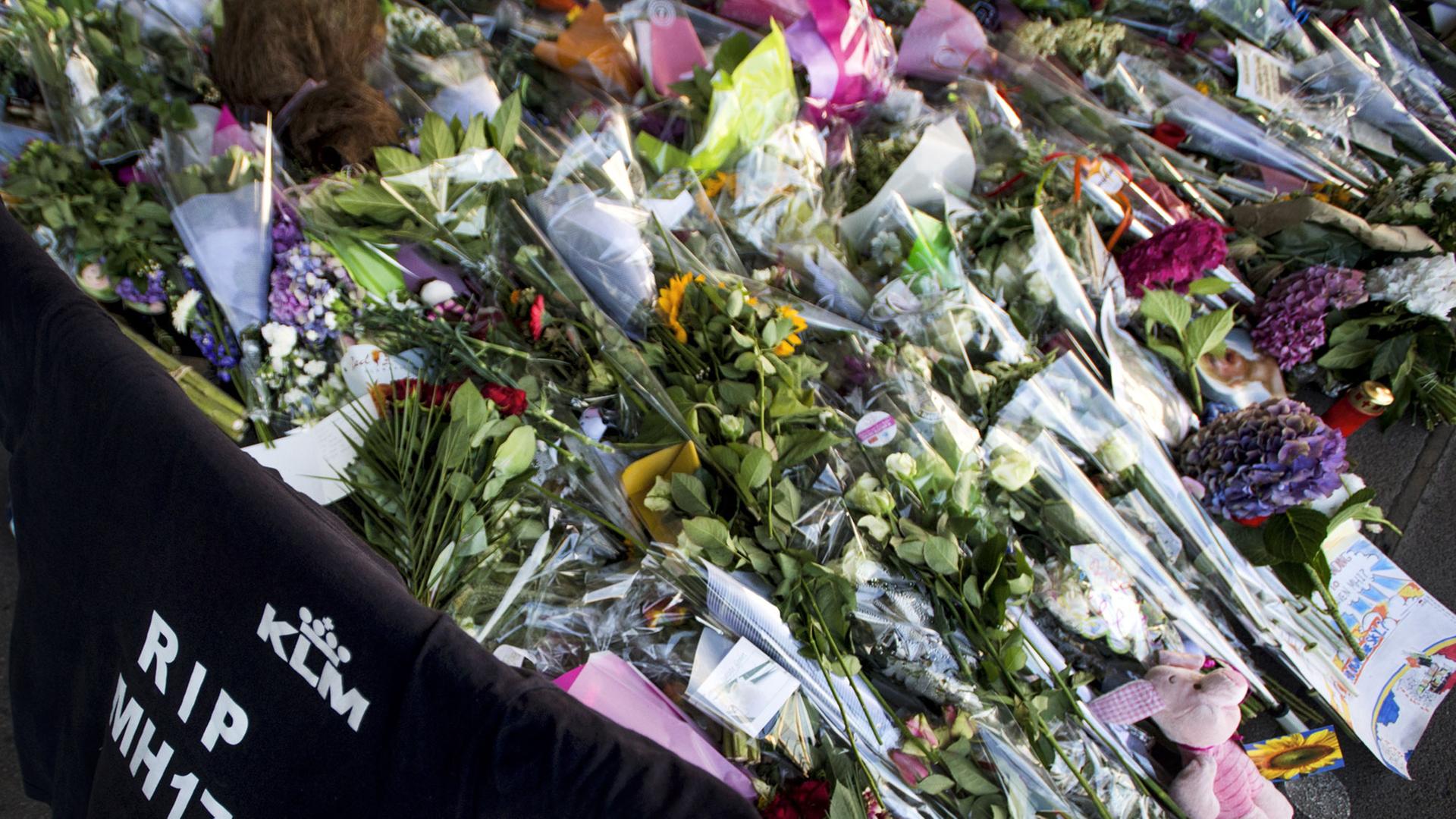 Blumen, Kerzen und T-Shirt mit der Aufschrift "RIP MH17" erinnern am niederländischen Flughafen Schiphol an die Opfer der in der Ost-Ukraine abgestürzten Malaysia-Airlines-Maschine. Blumen, Kerzen und T-Shirt mit der Aufschrift "RIP MH17" erinnern am niederländischen Flughafen Schiphol an die Opfer der in der Ost-Ukraine abgestürzten Malaysia-Airlines-Maschine.