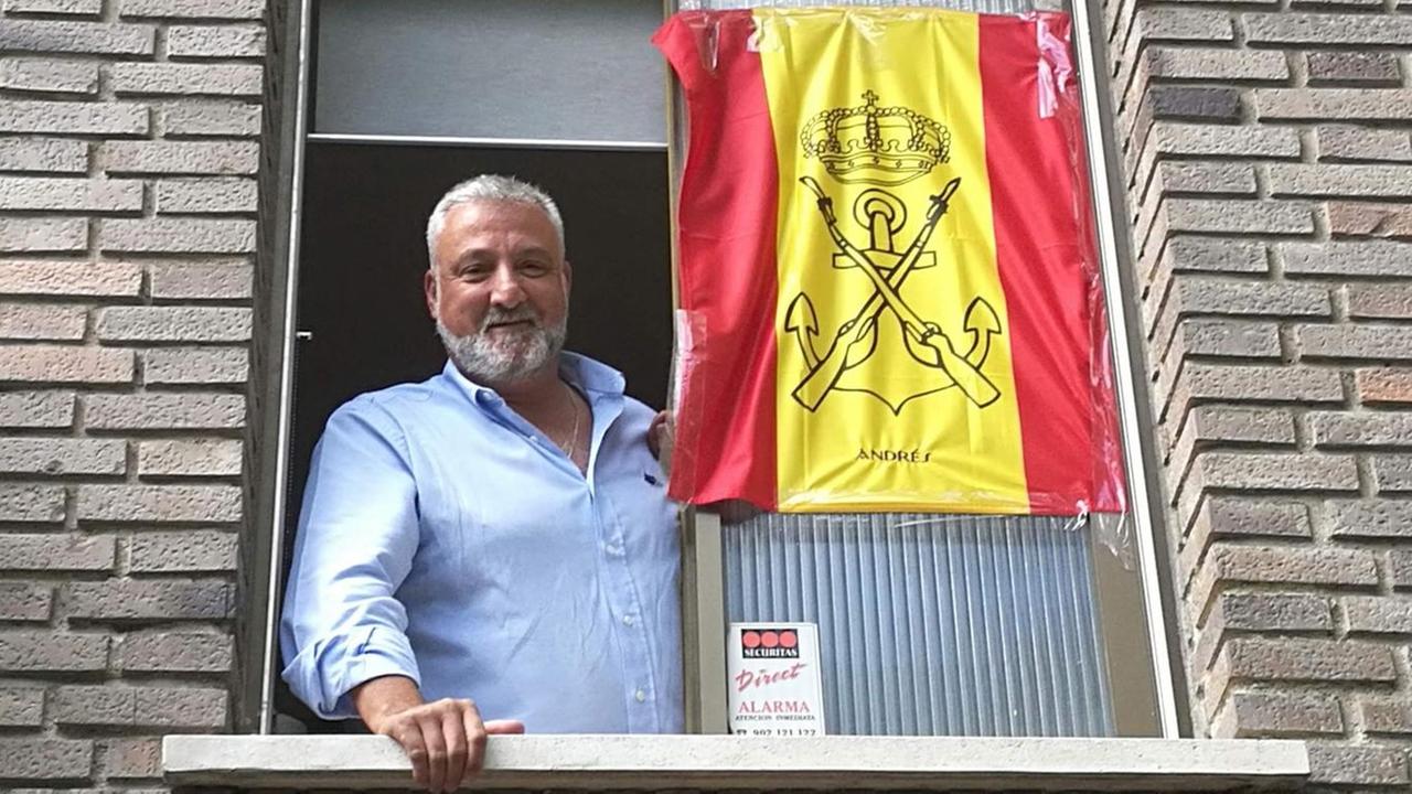 Kiko Zaragoza steht am Fenster neben seiner spanischen Fahne mit dem Wappen der Marine Kiko Zaragoza steht am Fenster neben seiner spanischen Fahne mit dem Wappen der Marine