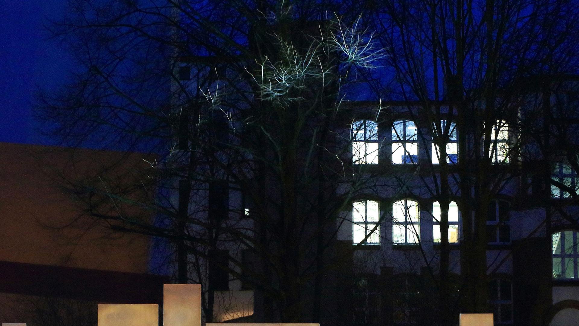 Außenansicht eines Universitätsgebäudes bei Nacht mit hellerleuchteten Fenstern, im Vordergrund der Schriftzug "Universität". Außenansicht eines Universitätsgebäudes bei Nacht mit hellerleuchteten Fenstern, im Vordergrund der Schriftzug "Universität".