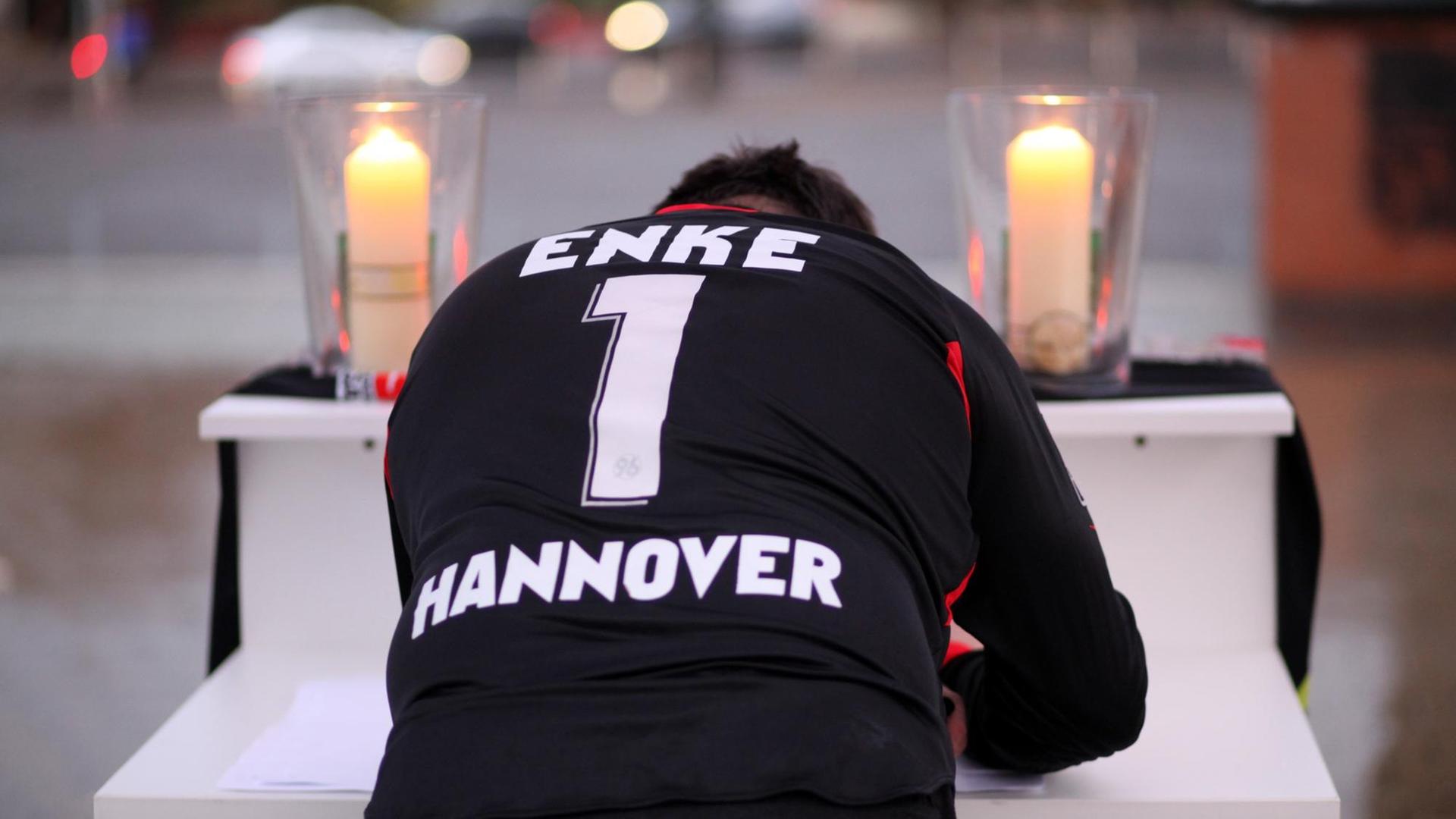 ARCHIV - Ein Hannover 96-Fan trägt sich am 11.11.2009 vor der AWD-Arena in Hannover in ein Kondolenzbuch für den toten Nationaltorwart Robert Enke ein. Enkes Todestag jährt sich am 10.11.2011 zum zweiten Mal. Foto: Kay Nietfeld dpa/lni (zu dpa-KORR "Stiftung: Mehr Sensibilität seit dem Enke-Tod" vom 09.11.2011) +++(c) dpa - Bildfunk+++ | Verwendung weltweit ARCHIV - Ein Hannover 96-Fan trägt sich am 11.11.2009 vor der AWD-Arena in Hannover in ein Kondolenzbuch für den toten Nationaltorwart Robert Enke ein. Enkes Todestag jährt sich am 10.11.2011 zum zweiten Mal. Foto: Kay Nietfeld dpa/lni (zu dpa-KORR "Stiftung: Mehr Sensibilität seit dem Enke-Tod" vom 09.11.2011) +++(c) dpa - Bildfunk+++ | Verwendung weltweit