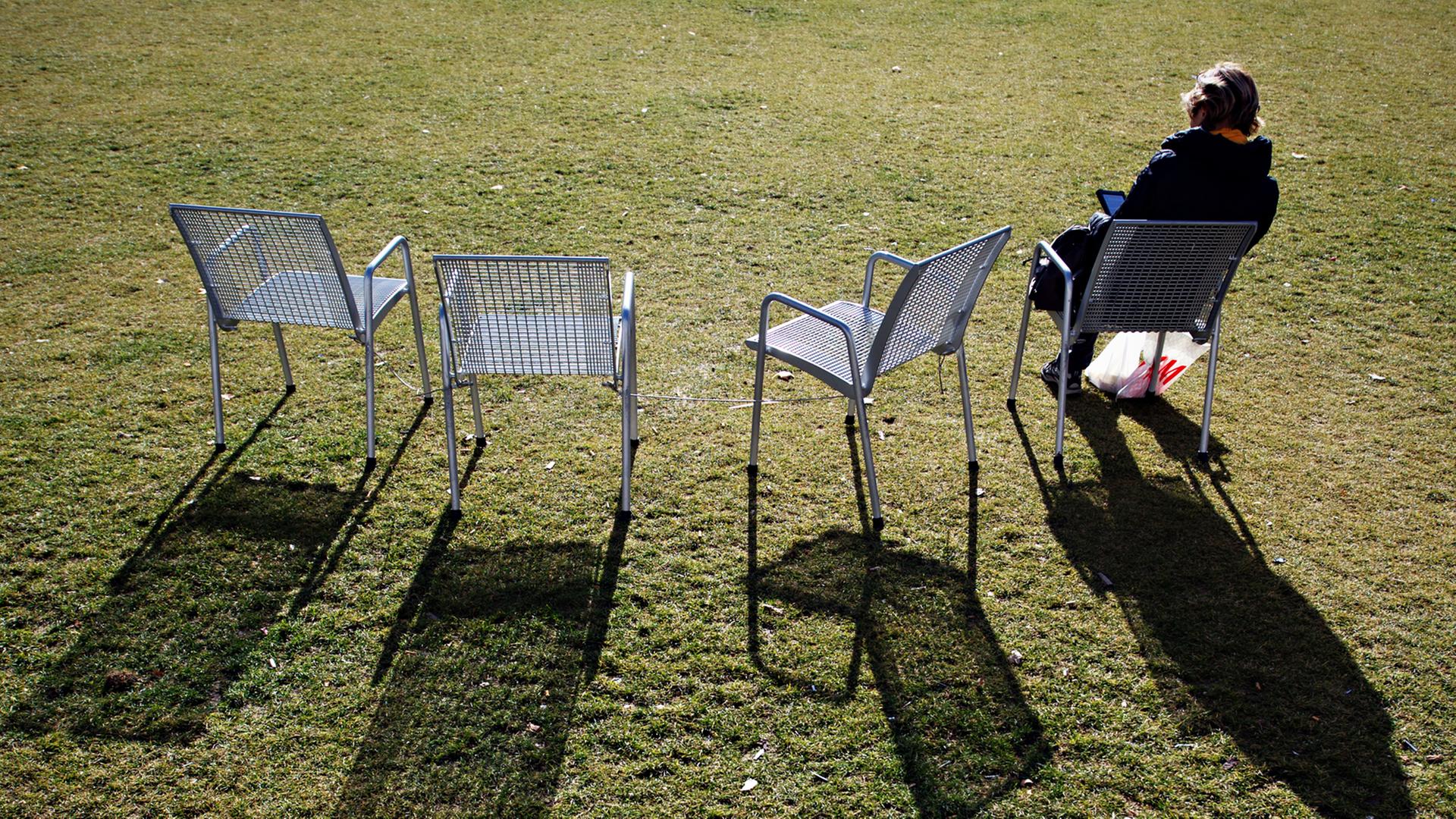 Eine Frau sitzt am 17.02.2014 in München (Oberbayern) bei Sonnenschein auf einem Stuhl. Milde Temperaturen und sonniges Wetter laden zum Sonnenbaden ein.