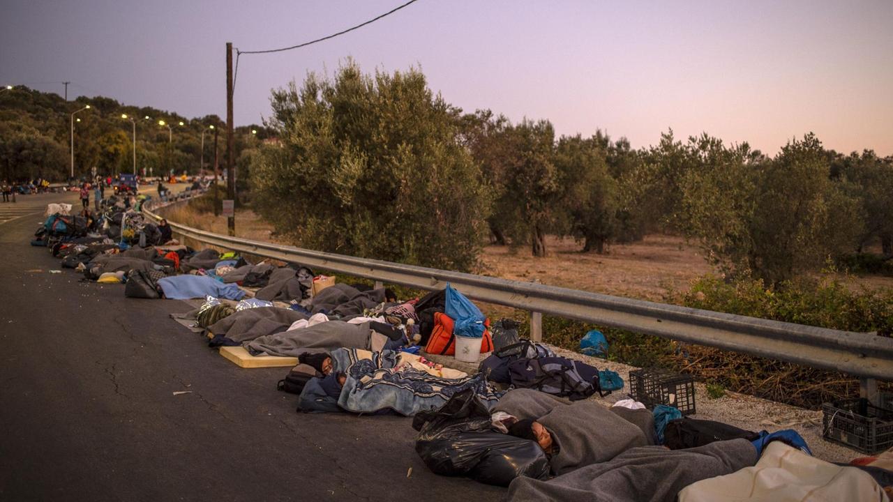 Geflüchtete aus Moria schlafen nebeneinander auf dem Standstreifen einer Straße. Geflüchtete aus Moria schlafen nebeneinander auf dem Standstreifen einer Straße.