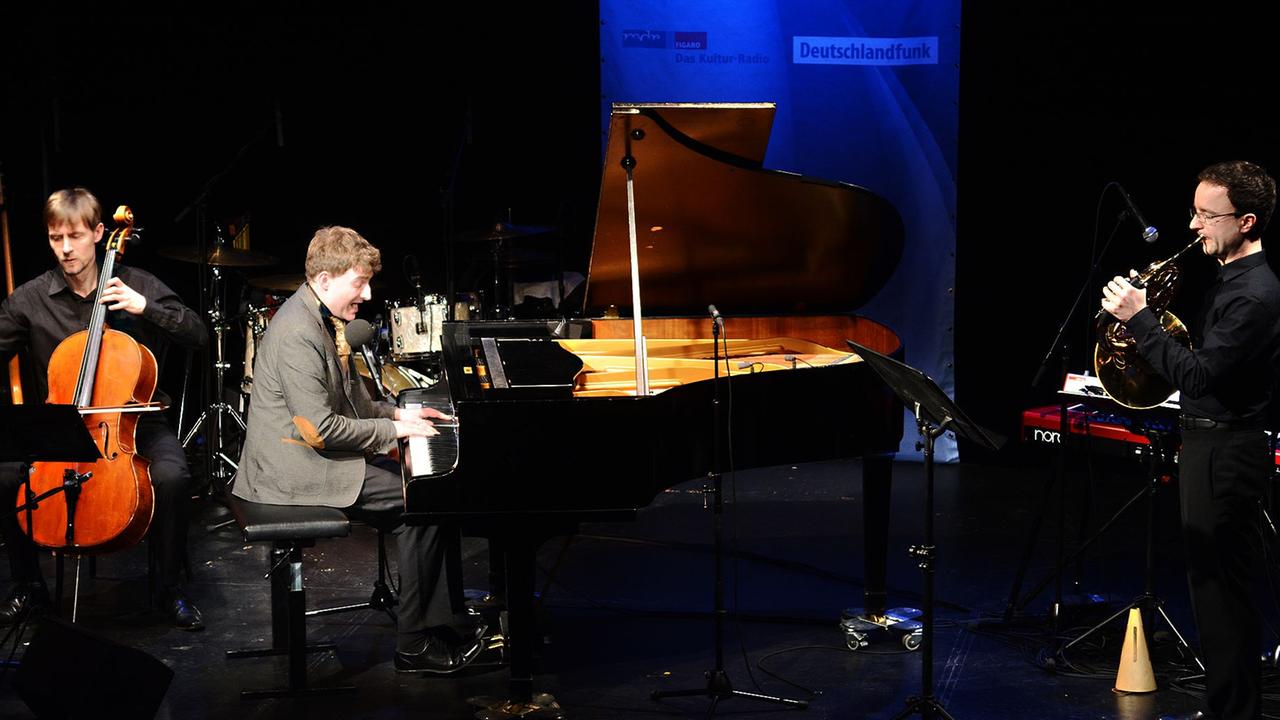 Sebastian Krämer sitzt am Flügel auf der Bühne des Dresdner Theaterkahns links neben ihm ein Cellist und rechts vom ihm ein Hornist