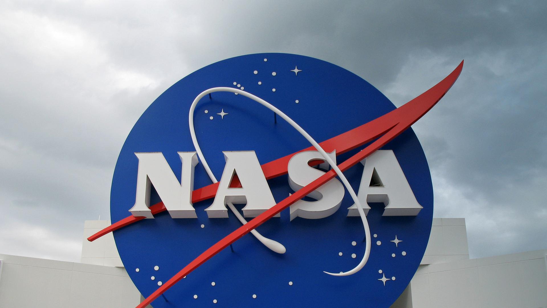 Nasa-Logo auf dem Gelände in Cape Canaveral, weiße Schrift auf blauem Untergrund, mit rotem Strich über der Schrift. Nasa-Logo auf dem Gelände in Cape Canaveral, weiße Schrift auf blauem Untergrund, mit rotem Strich über der Schrift.