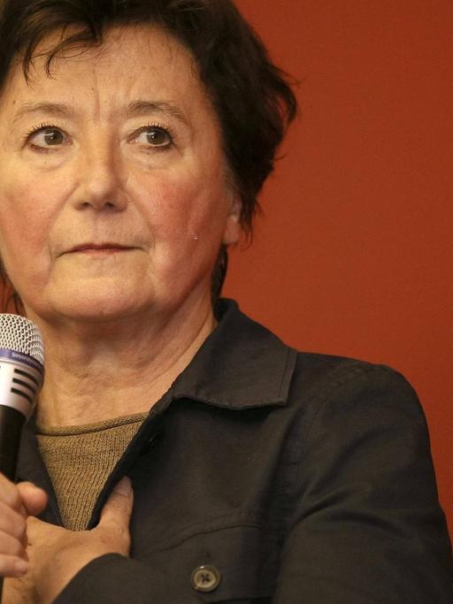 Brigitte Fehrle im Porträt mit einem Mikrofon in der Hand