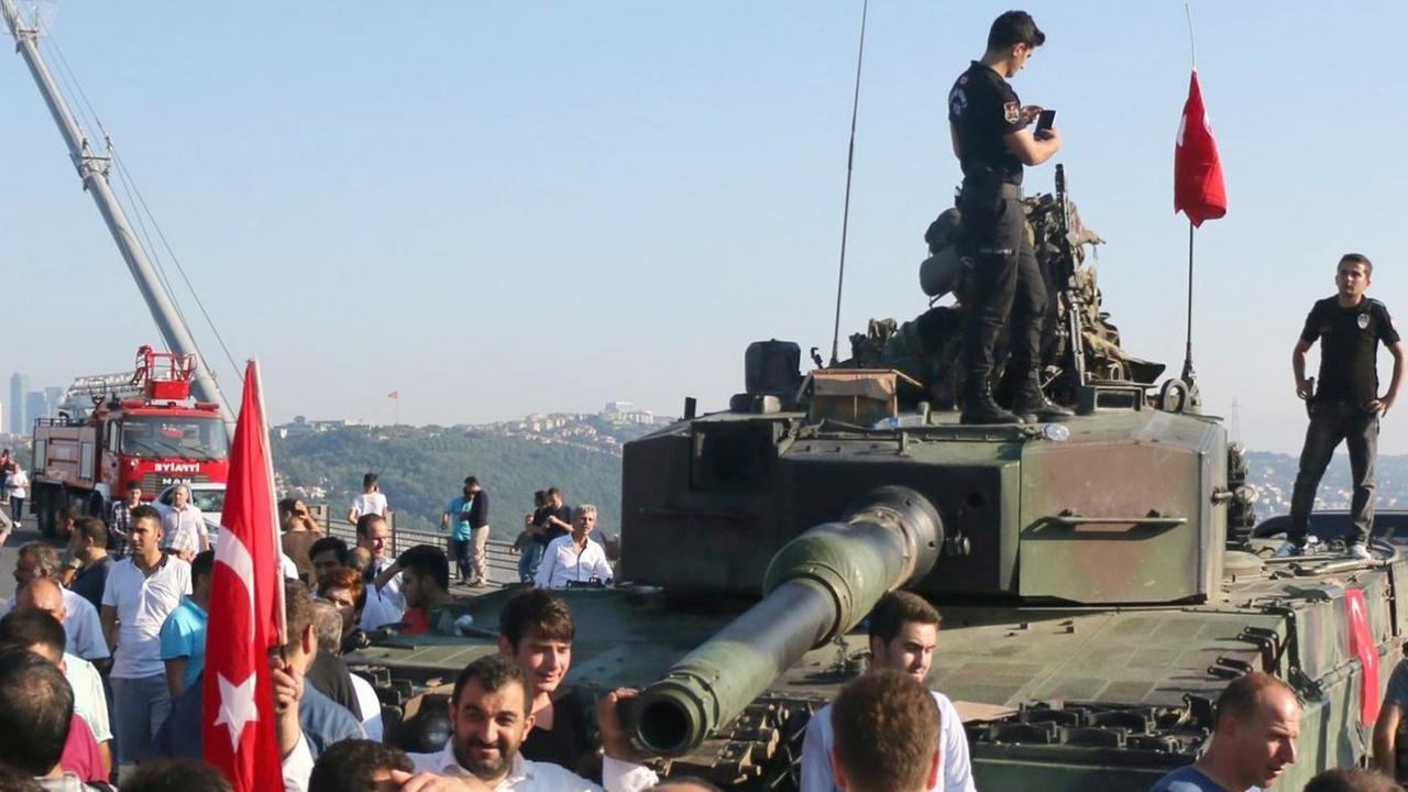 Polizisten und Erdogan-Anhänger scharen sich um einen Panzer vor der Bosporusbrücke in Istanbul. Polizisten und Erdogan-Anhänger scharen sich um einen Panzer vor der Bosporusbrücke in Istanbul.