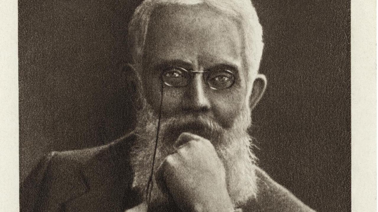 Eine schwarzweiße Foto-Postkarte zeigt Franz Mehring mit langem, grauen Vollbart und Haupthaar und runder Metallbrille, nachdenklich das Kind auf eine Hand stützend Eine schwarzweiße Foto-Postkarte zeigt Franz Mehring mit langem, grauen Vollbart und Haupthaar und runder Metallbrille, nachdenklich das Kind auf eine Hand stützend