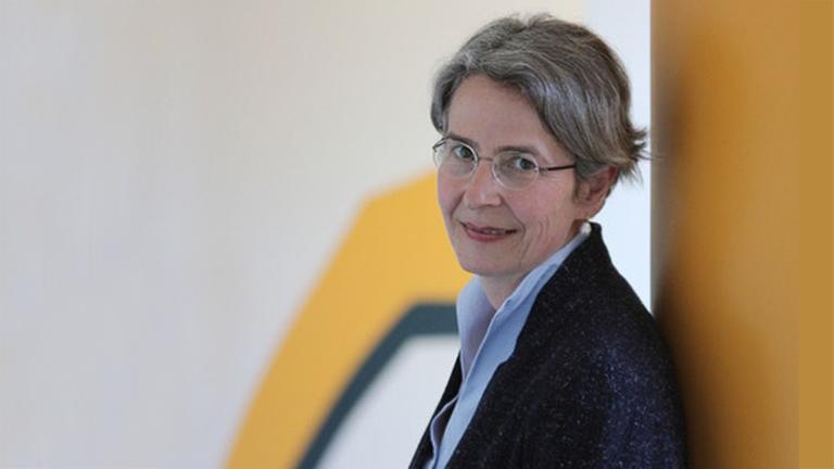 Julika Griem lehnt sich an eine gelblich angemalte Wand und blickt in die Kamera. Sie trägt die Haare gescheitelt und hat eine Brille. Julika Griem lehnt sich an eine gelblich angemalte Wand und blickt in die Kamera. Sie trägt die Haare gescheitelt und hat eine Brille.
