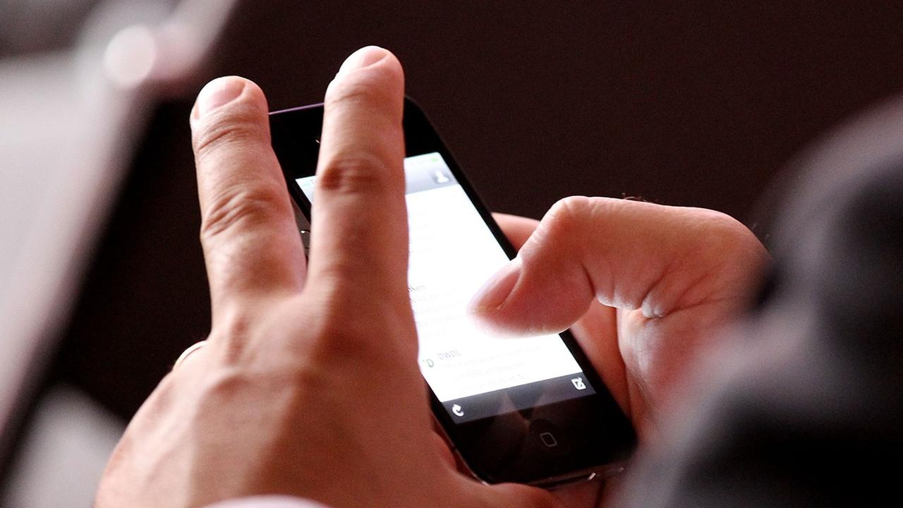 Mann im Anzug hat ein Smartphone in der Hand Mann im Anzug hat ein Smartphone in der Hand