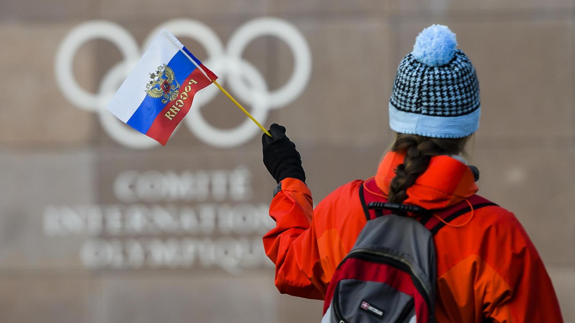 Eine Frau hält eine russische Fahne vor dem IOC-Gebäude in Lausanne. Eine Frau hält eine russische Fahne vor dem IOC-Gebäude in Lausanne.