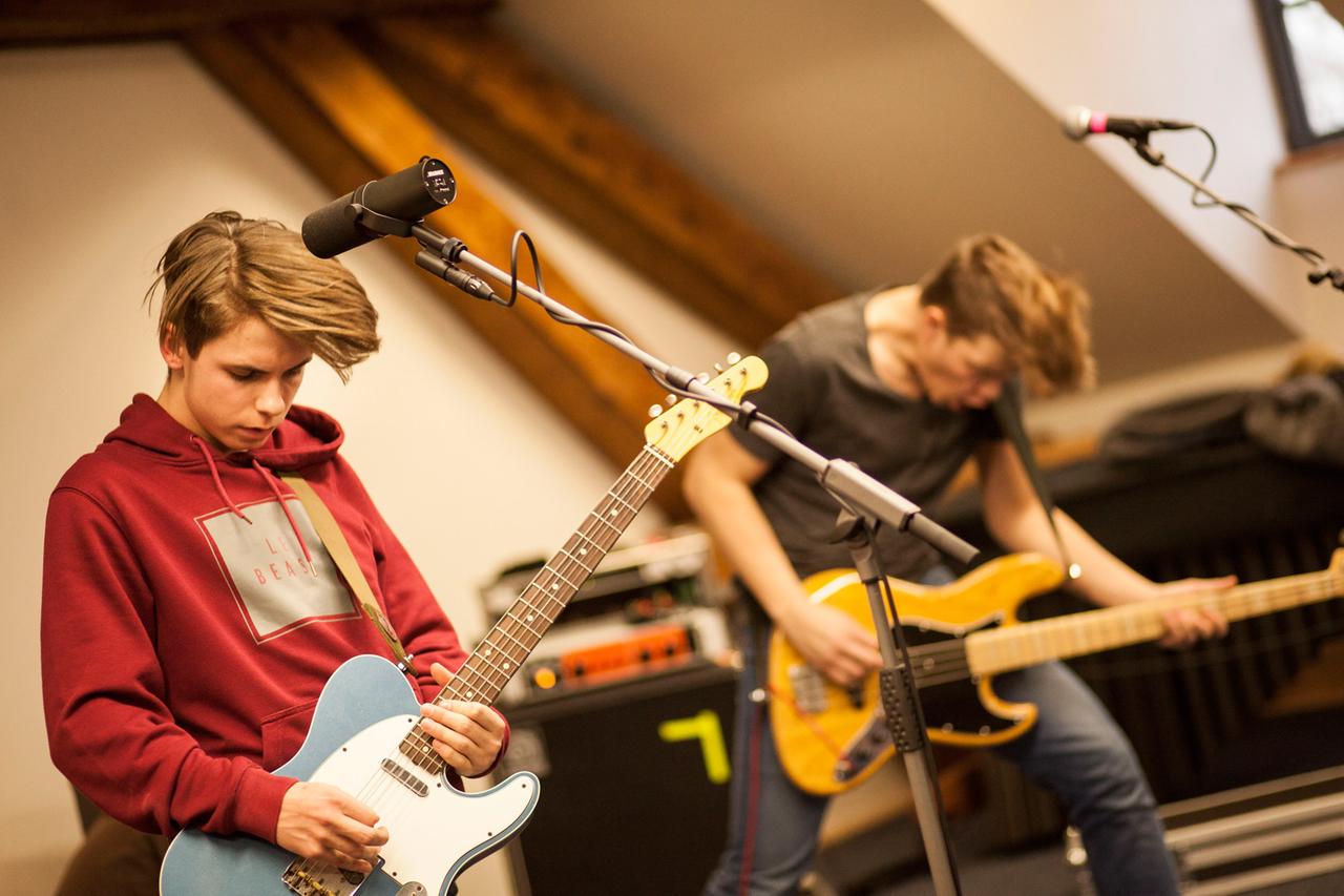 Ein Gitarrist und im Hintergrund ein Bassist spielen Rockmusik. Ein Gitarrist und im Hintergrund ein Bassist spielen Rockmusik.
