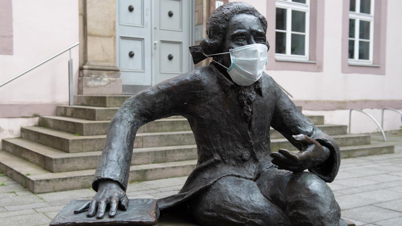 Die Bronzeskulptur im Akademiehof der Niedersächsischen Staats- und Universitätsbibliothek, die den Göttinger Physikers Georg Christoph Lichtenberg darstellt, trägt einen Mundschutz Die Bronzeskulptur im Akademiehof der Niedersächsischen Staats- und Universitätsbibliothek, die den Göttinger Physikers Georg Christoph Lichtenberg darstellt, trägt einen Mundschutz