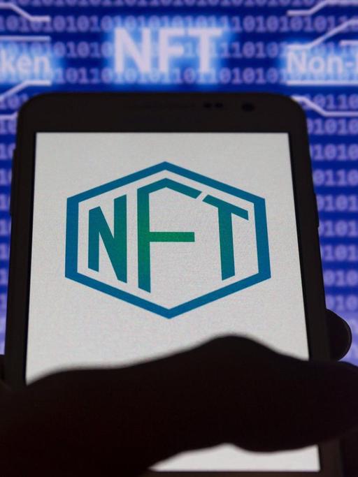 Der abkürzende Schriftzug NFT und seine Entsprechung non-fungible-token auf einem Computer-Bildschirm dargestellt.