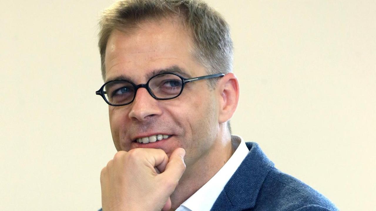 Stefan Liebich, Mitglied der Berliner Linken und des Bundestages, nimmt am 30.05.2015 in Berlin am Landesparteitag der Partei Die Linke teil. Porträt eines Mannes im Anzug, der freundlich lächelnd in die Kamera grinst, das Kinn aufgestützt in der Hand, mit Brille. Stefan Liebich, Mitglied der Berliner Linken und des Bundestages, nimmt am 30.05.2015 in Berlin am Landesparteitag der Partei Die Linke teil. Porträt eines Mannes im Anzug, der freundlich lächelnd in die Kamera grinst, das Kinn aufgestützt in der Hand, mit Brille.