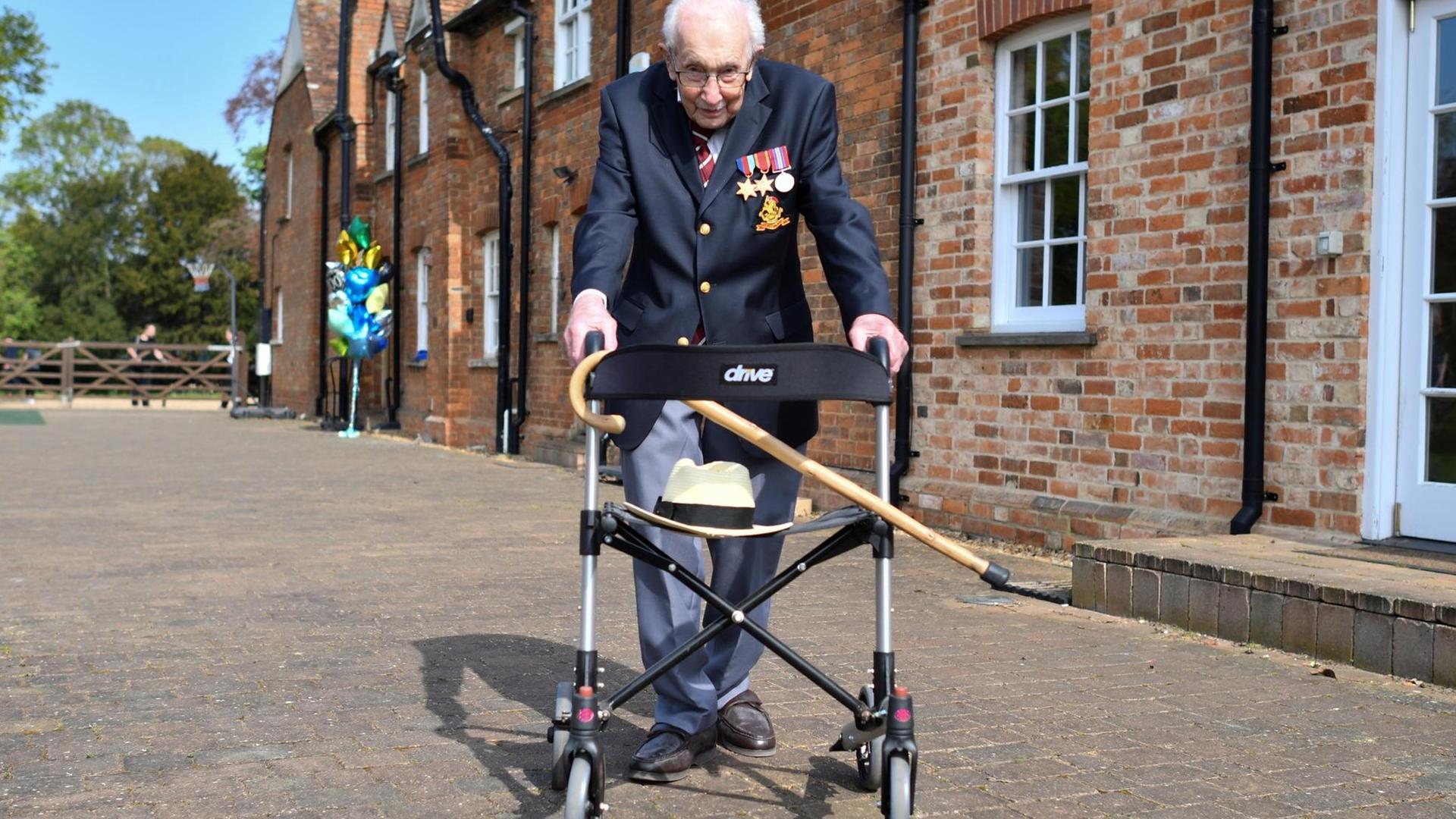 Tom Moore zeigt stolz seine Ritter-Medaille. Im Hintergrund sieht man Windsor Castle. Tom Moore zeigt stolz seine Ritter-Medaille. Im Hintergrund sieht man Windsor Castle.