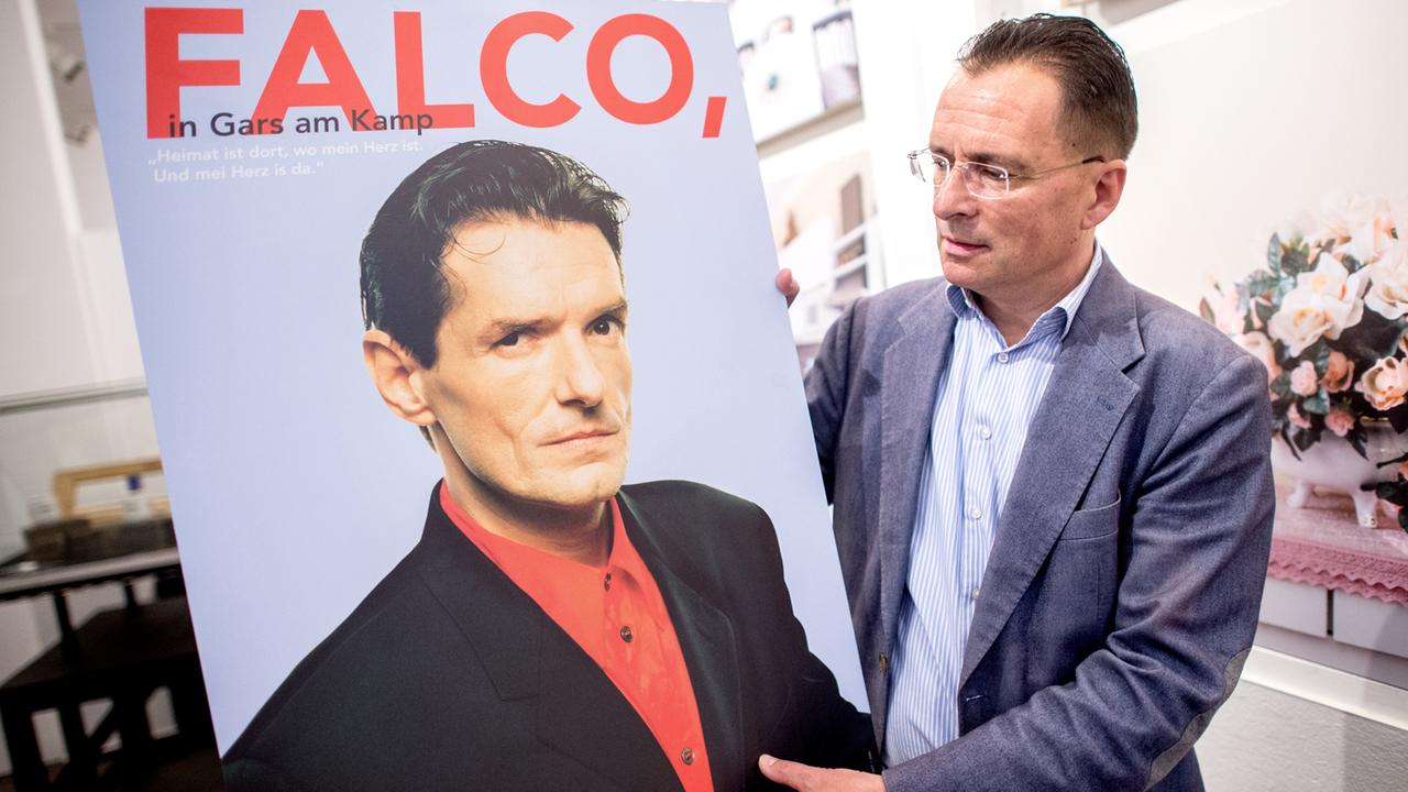 Museumsdirektor Carsten Niemann mit einem Plakat der Ausstellung "Falco, in Gars am Kamp".