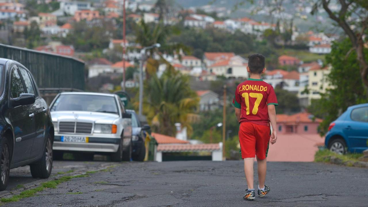 Ein Junge mit einem Ronaldo-T-Shirt läuft durch die Nachbarschaft auf der Insel Madeira.