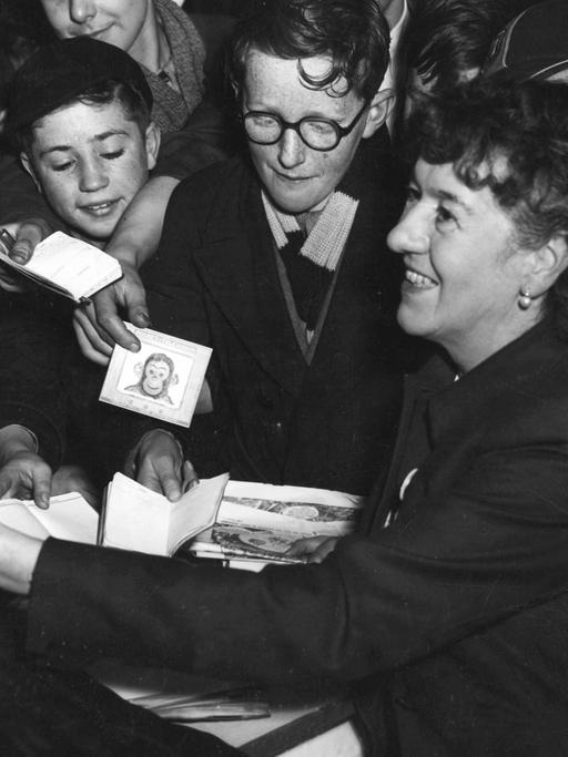 Die Schriftstellerin Enid Blyton umringt von Schuljungen während einer Autogrammstunde im Jahr 1953.