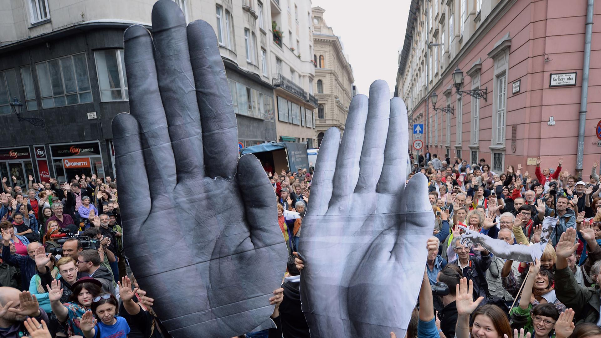 Demonstranten in Budapest machen "Stopp"-Zeichen mit ihren Händen, um gegen den Umgang der Regierung mit Nichtregierungsorganisationen zu protestieren. Demonstranten in Budapest machen "Stopp"-Zeichen mit ihren Händen, um gegen den Umgang der Regierung mit Nichtregierungsorganisationen zu protestieren.