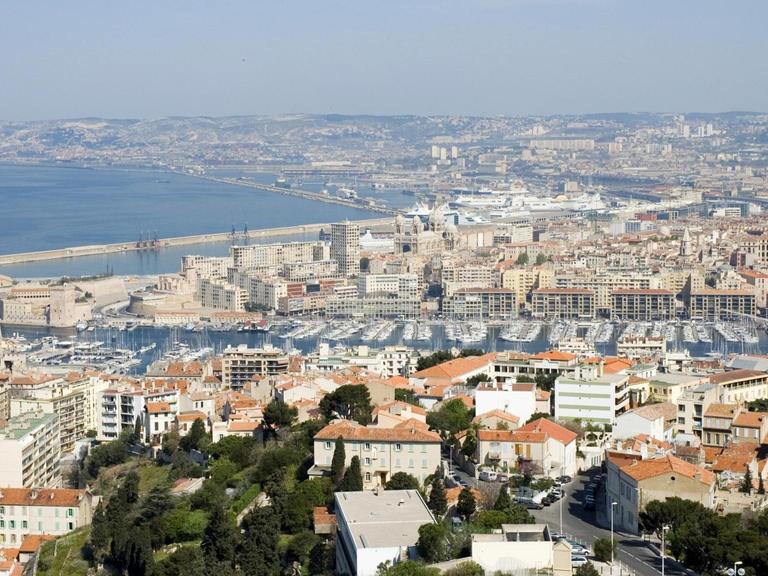 Stadtansicht von Marseille, zu erkennen ist unter anderem der Hafen und das Mittelmeer.