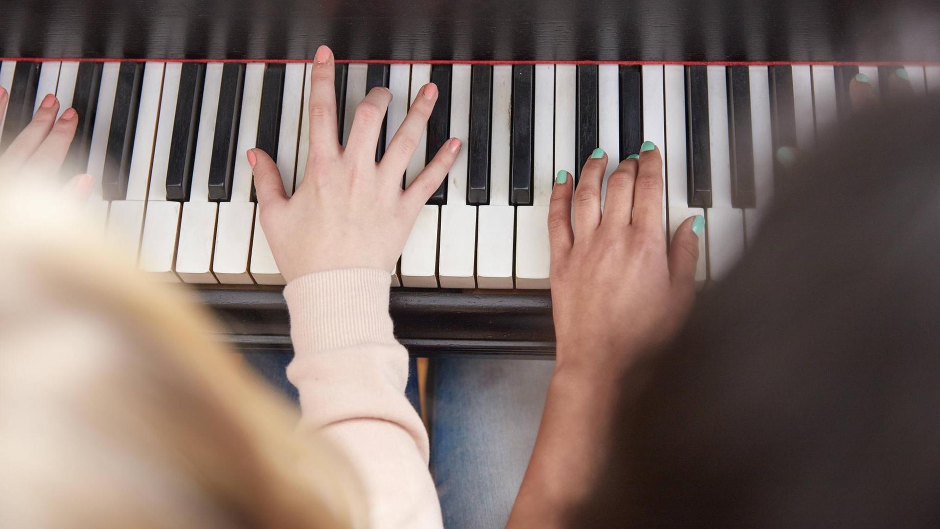 Nahaufnahme von zwei Mädchen, die Klavier spielen Nahaufnahme von zwei Mädchen, die Klavier spielen