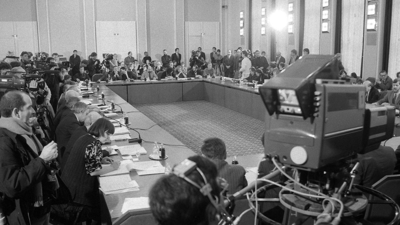 Versammlung im Januar 1990 am Zentralen Runden Tisch im Konferenzgebäude des Ministerrates der DDR am Schloss Niederschönhausen (heute Schönhausen) in Berlin-Pankow. In der Wendezeit war mit dem Wegbrechen hierarchischer Strukturen ein Machtvakuum in der DDR entstanden. Der Zentrale Runde Tisch, an dem Vertreter von Parteien, der Kirche, gesellschaftlichen Institutionen und der neuen Bürgerbewegung mitarbeiteten, beeinflusste viele Entscheidungen der Übergangsregierung Modrow und erfuhr wegen seiner Bedeutung für das Land ein großes Medieninteresse. Versammlung im Januar 1990 am Zentralen Runden Tisch im Konferenzgebäude des Ministerrates der DDR am Schloss Niederschönhausen (heute Schönhausen) in Berlin-Pankow. In der Wendezeit war mit dem Wegbrechen hierarchischer Strukturen ein Machtvakuum in der DDR entstanden. Der Zentrale Runde Tisch, an dem Vertreter von Parteien, der Kirche, gesellschaftlichen Institutionen und der neuen Bürgerbewegung mitarbeiteten, beeinflusste viele Entscheidungen der Übergangsregierung Modrow und erfuhr wegen seiner Bedeutung für das Land ein großes Medieninteresse.