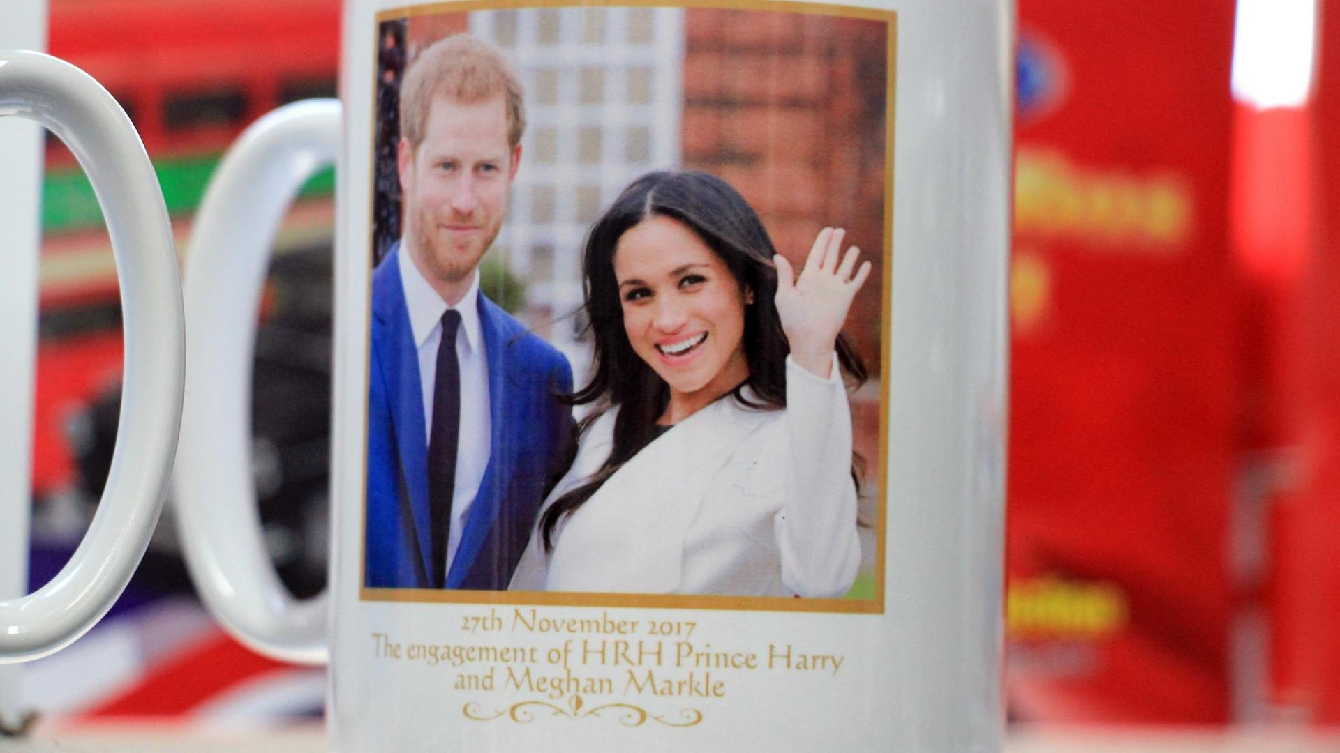 ARCHIV - 24.02.2018, Großbritannien, Windsor: Eine Tasse mit dem Abbild von Prinz Harry und Meghan Markle wird in einem Souvenir Shop zum Verkauf angeboten. Vor allem Touristen aus den USA gehören zu den besten Kunden in Andenkenläden.