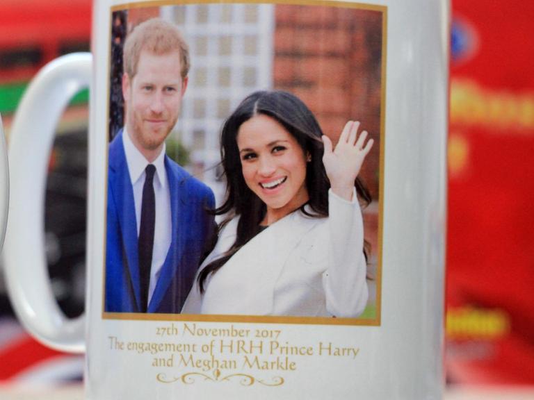 ARCHIV - 24.02.2018, Großbritannien, Windsor: Eine Tasse mit dem Abbild von Prinz Harry und Meghan Markle wird in einem Souvenir Shop zum Verkauf angeboten. Vor allem Touristen aus den USA gehören zu den besten Kunden in Andenkenläden.