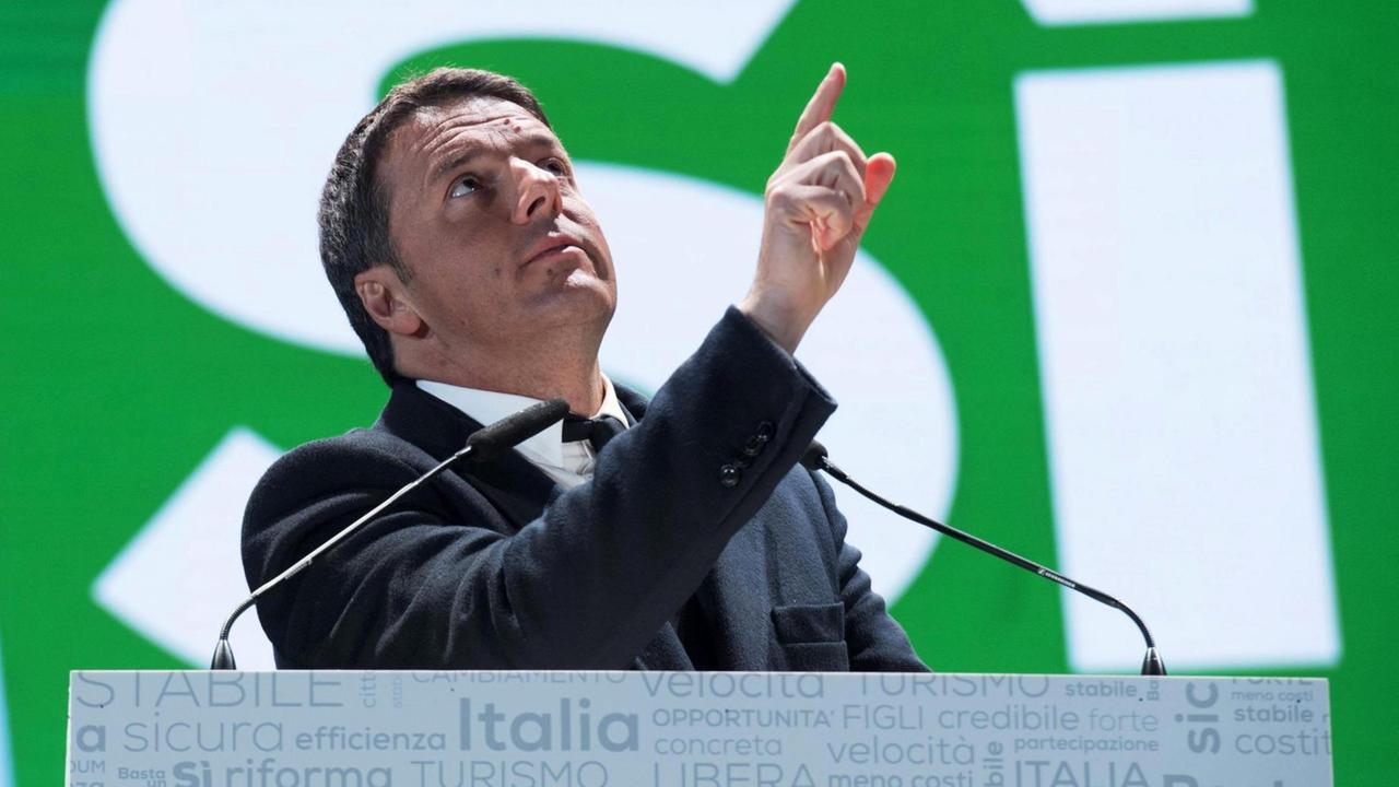 Renzi steht an einem Mikrofon vor einem grünen Plakat mit einer riesigen "Si"-Aufschrift und deutet mit dem Finger nach oben. Renzi steht an einem Mikrofon vor einem grünen Plakat mit einer riesigen "Si"-Aufschrift und deutet mit dem Finger nach oben.