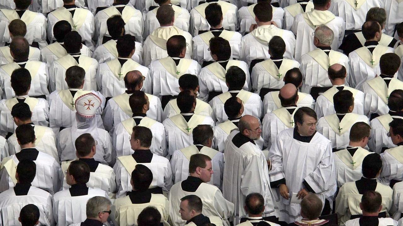 Zahlreiche Priester warten auf dem Petersplatz auf den Beginn einer heiligen Messe mit dem Papst. Zahlreiche Priester warten auf dem Petersplatz auf den Beginn einer heiligen Messe mit dem Papst.