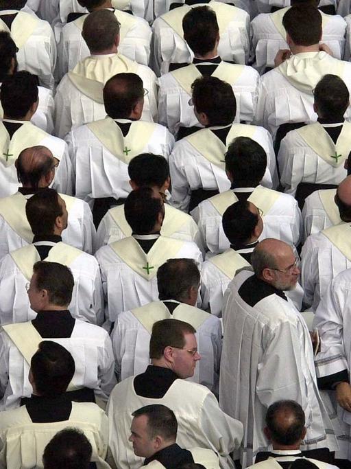 Zahlreiche Priester warten auf dem Petersplatz auf den Beginn einer heiligen Messe mit dem Papst.