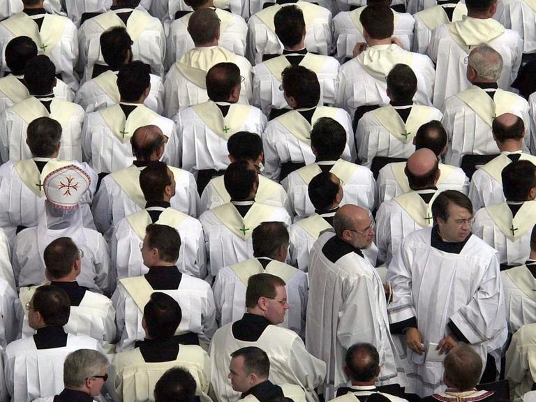Zahlreiche Priester warten auf dem Petersplatz auf den Beginn einer heiligen Messe mit dem Papst.
