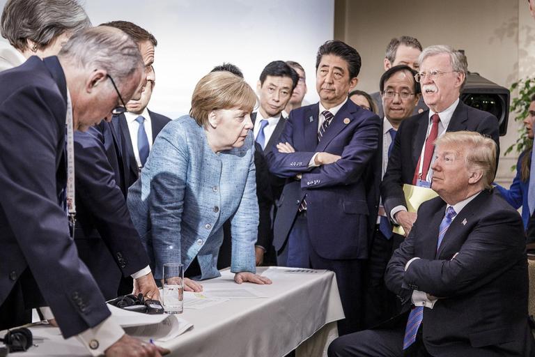 Merkel spricht mit Trump während Macron, Abe und Bolton zuhören. Merkel spricht mit Trump während Macron, Abe und Bolton zuhören.