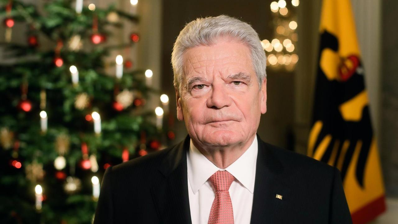 Gauck mit ernstem Blick vor einem Weihnachtsbaum und einer Bundesfahne. Gauck mit ernstem Blick vor einem Weihnachtsbaum und einer Bundesfahne.